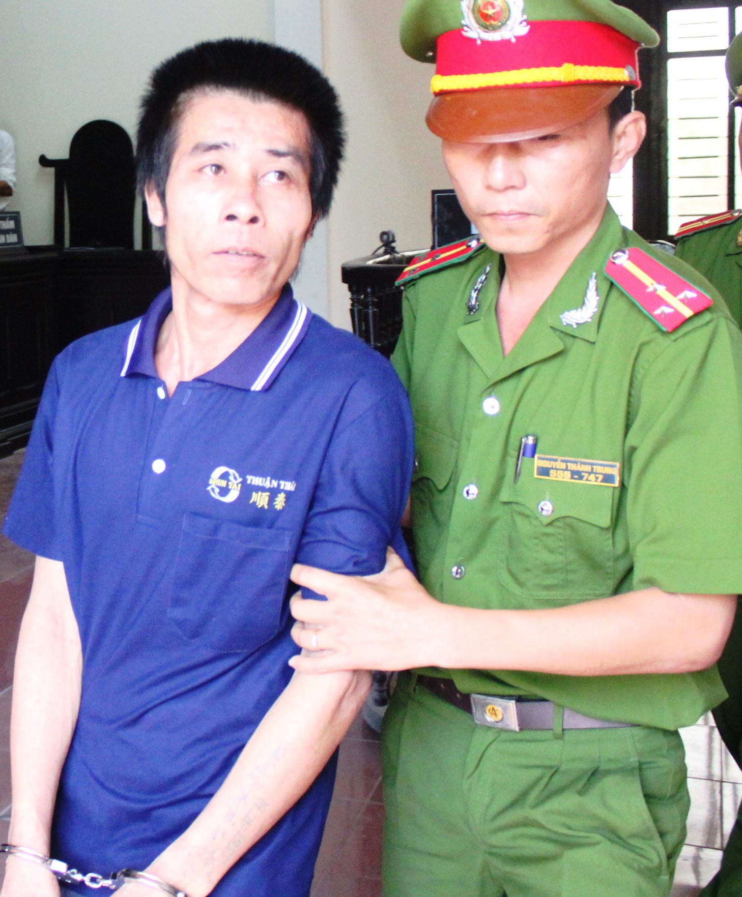 Vi Thanh Tùng được lực lượng dẫn giải ra xe khi phiên tòa kết thúc. Ảnh: Phạm Hòa.