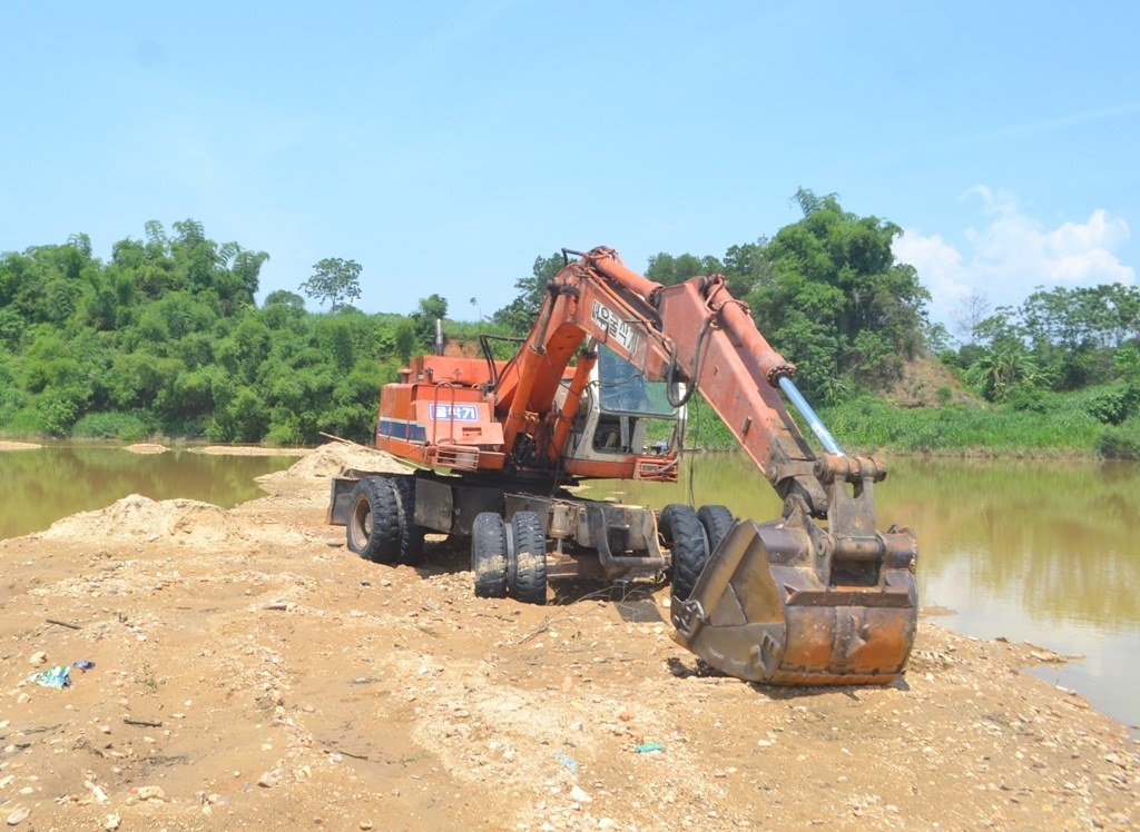 Chiếc máy xúc sau khi rơi xuống sông đã được vớt lên bờ. Ảnh: Phương Anh. 