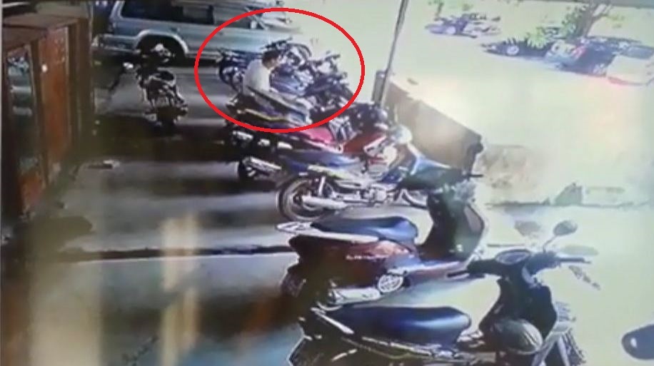 Thắng (vòng tròn đỏ) đang mò tìm tỏng cốp xe để chôm tài sản. Ảnh: Cắt từ clip.