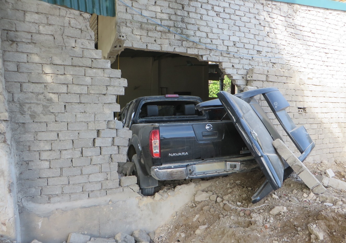 Ôtô bán tải nằm lọt thỏm trong nhà dân, một đoạn tường bị đổ sập. Ảnh: Hương Nhàn.