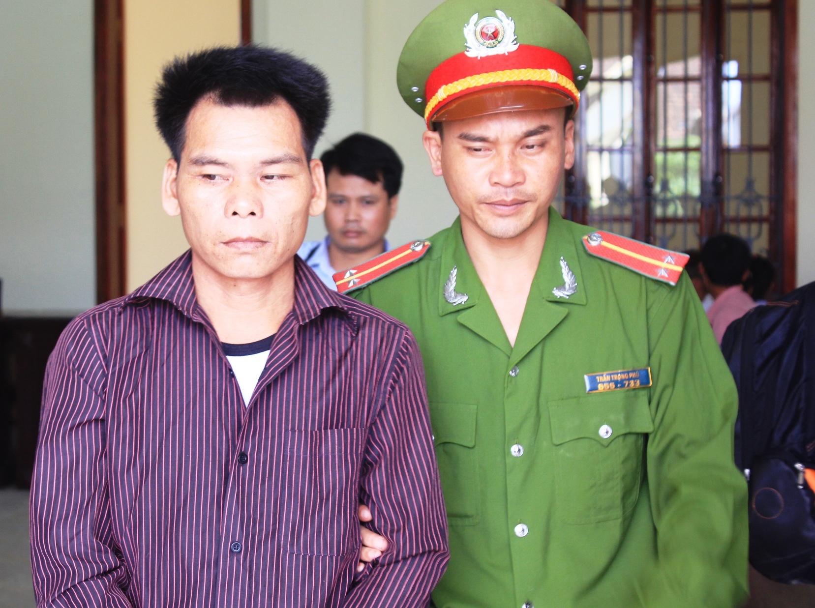 Bị cáo Lô Văn Phong được cảnh sát dẫn giải ra xe thùng sau khi phiên tòa kết thúc. Ảnh: Phạm Hòa.