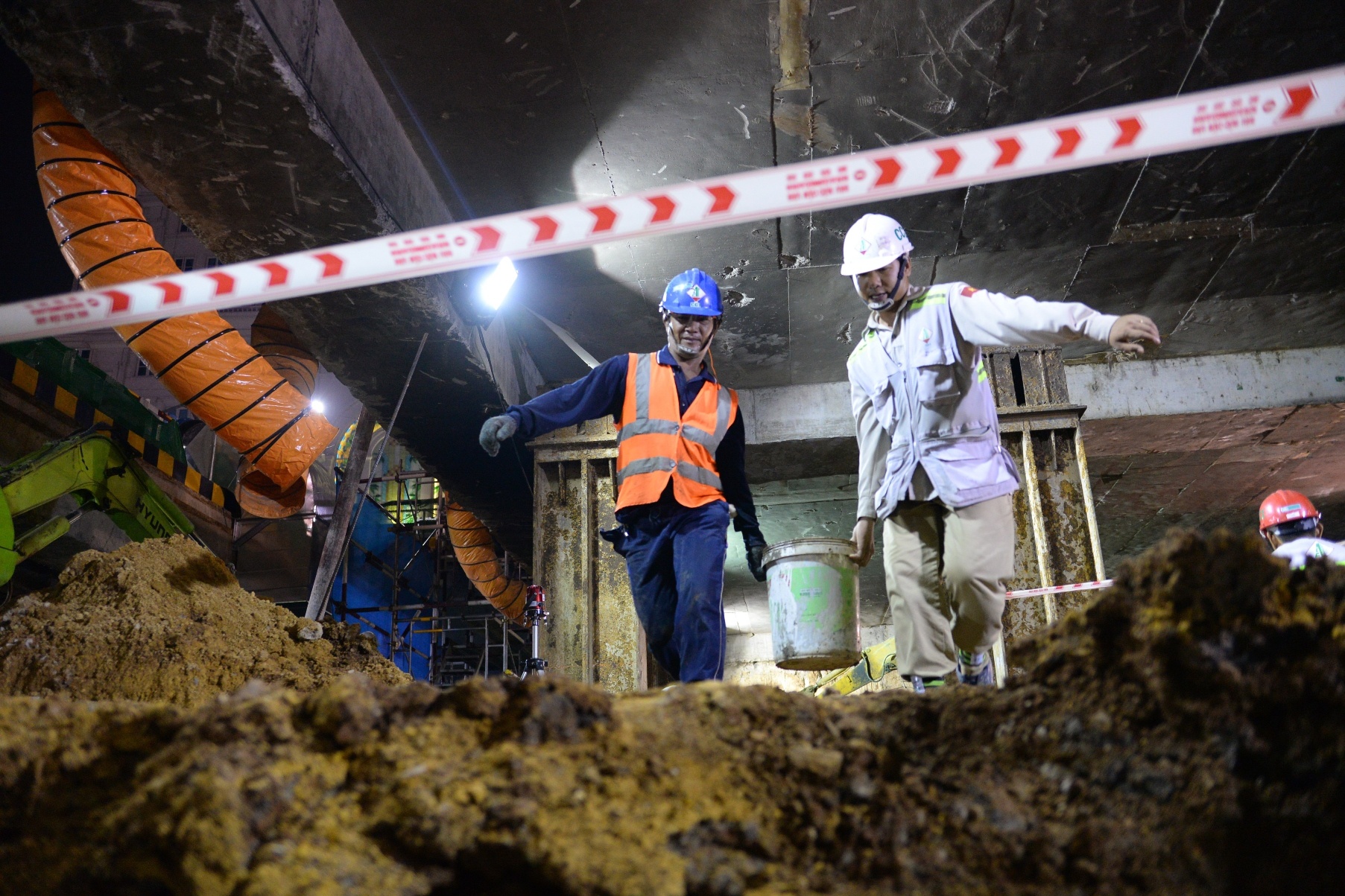 Ông Ngô Quang Ngại, quản lý an toàn dự án metro số 1, nói: “Công nhân phải đeo khẩu trang có than hoạt tính để lọc chất độc, mặc áo bảo hộ có phản quang. Nón bảo hộ phải có tem dán đã huấn luyện về điều kiện an toàn khi làm việc dưới hầm. Trong ảnh: Việc thi công dưới lòng đất khiến việc đi lại của các công nhân gặp nhiều khó khăn và nguy hiểm.