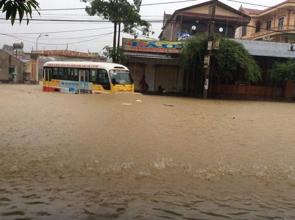 Xe buýt chạy dưới đường ngập để đưa đón khách. Ảnh: Anh Thơ.