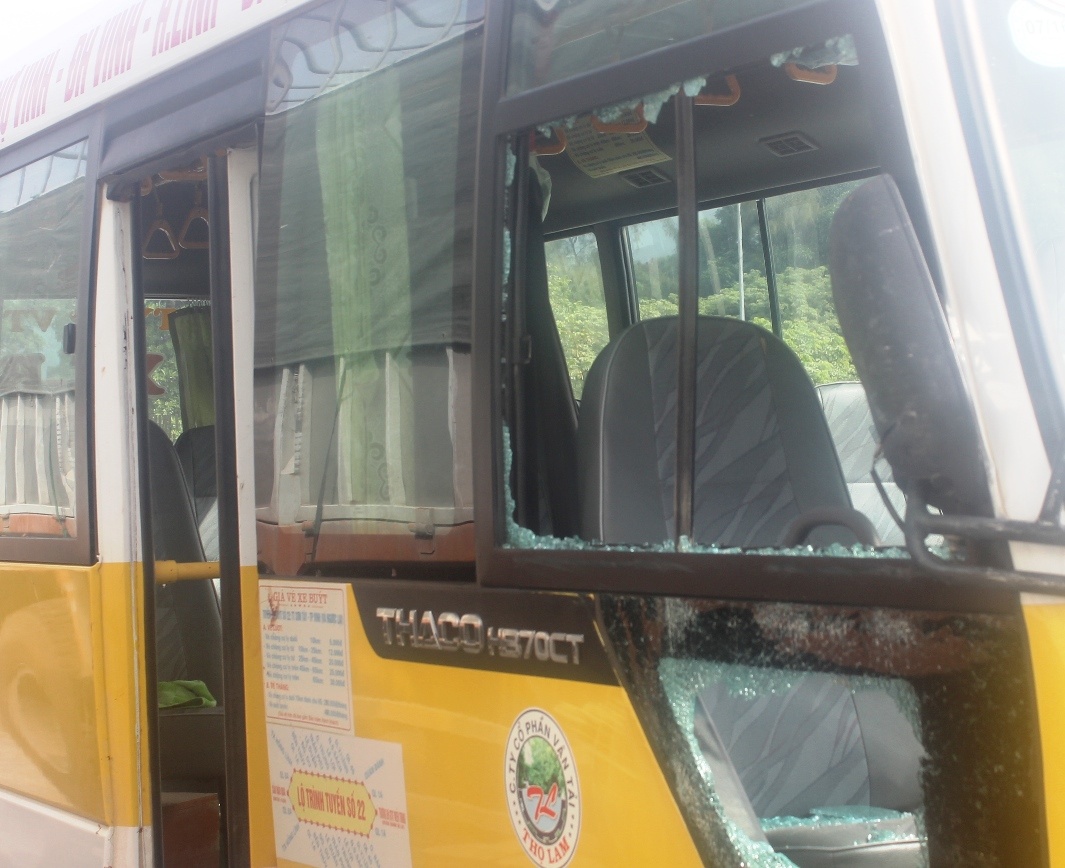 Xe buýt bị ném vỡ kinh hai bên, kính chắn gió phía trước bị rạn nứt. Ảnh: Phạm Hòa.