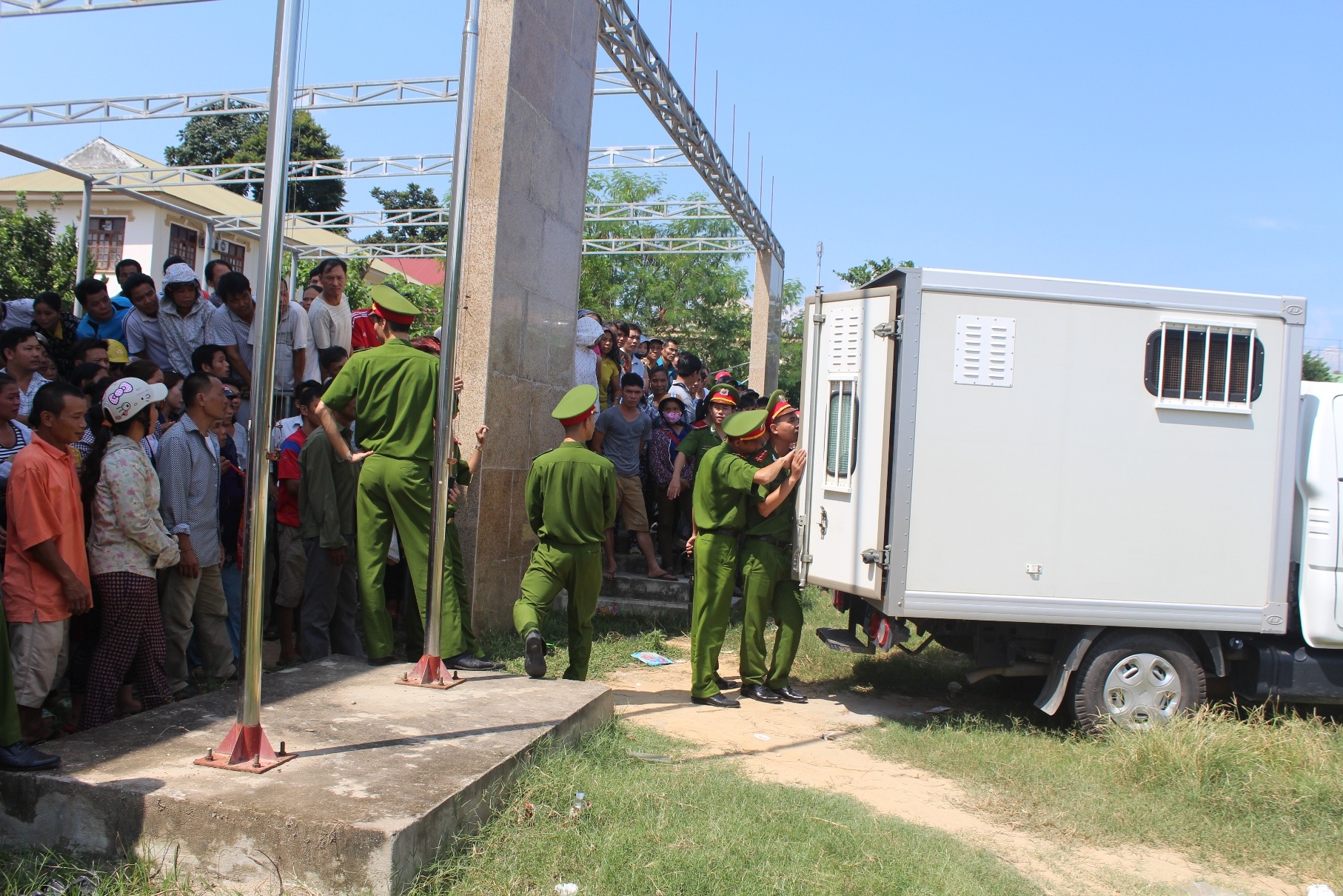 Nhiều người dân bíu lấy hàng rào nhìn bị cáo Vi Văn Hai lần cuối trước khi lên xe thùng về trại giam. 
