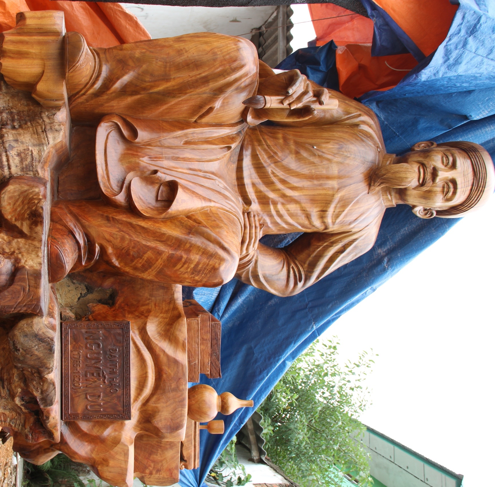 Anh Huy cho biết, phải thuê rất nhiều tốp thợ, mỗi tốp 2 người để làm từng công đoạn như cắt gỗ, tạc thô. Về phần tạc tượng, anh đích thân ra miền Bắc tìm những người thợ giỏi về chế tác để thuê trong đó có một nghệ nhân là thợ cả ở tỉnh Bắc Giang đảm nhiệm. Pho tượng gồm, chân dung Đại thi hào Nguyễn Du đang cầm bút, bên cạnh là hai cuốn sách, chén uống nước…