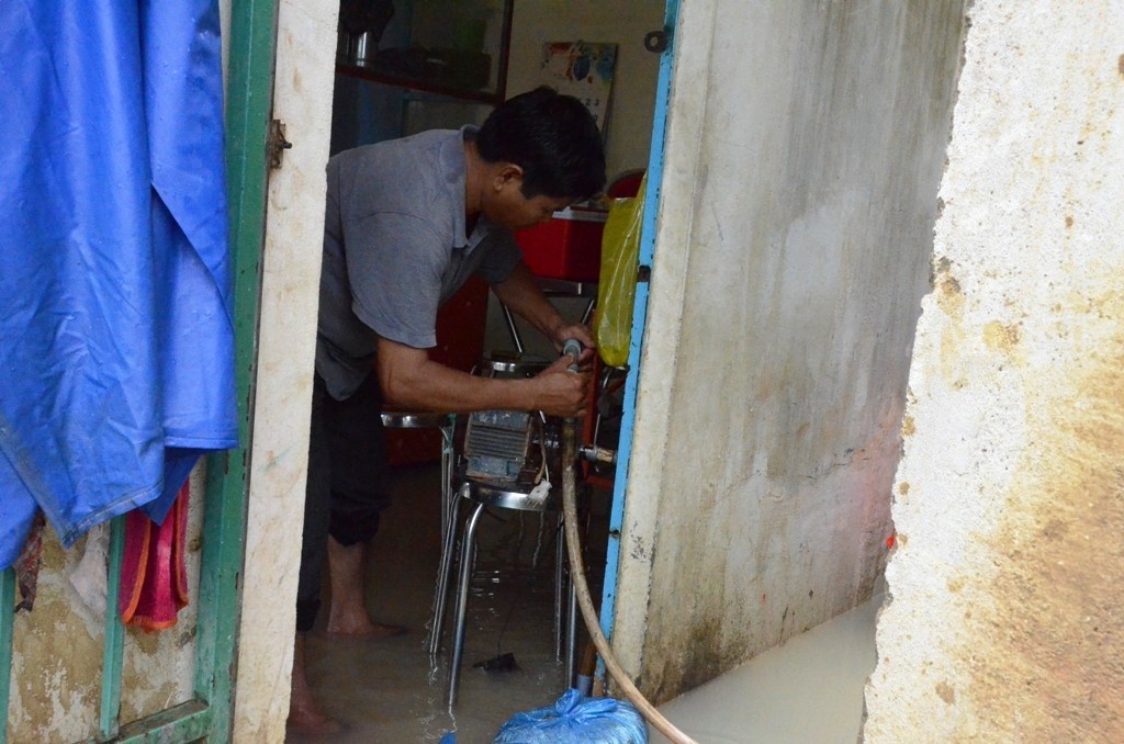 Người dân dùng máy bơm để bơm nước khỏi nhà.