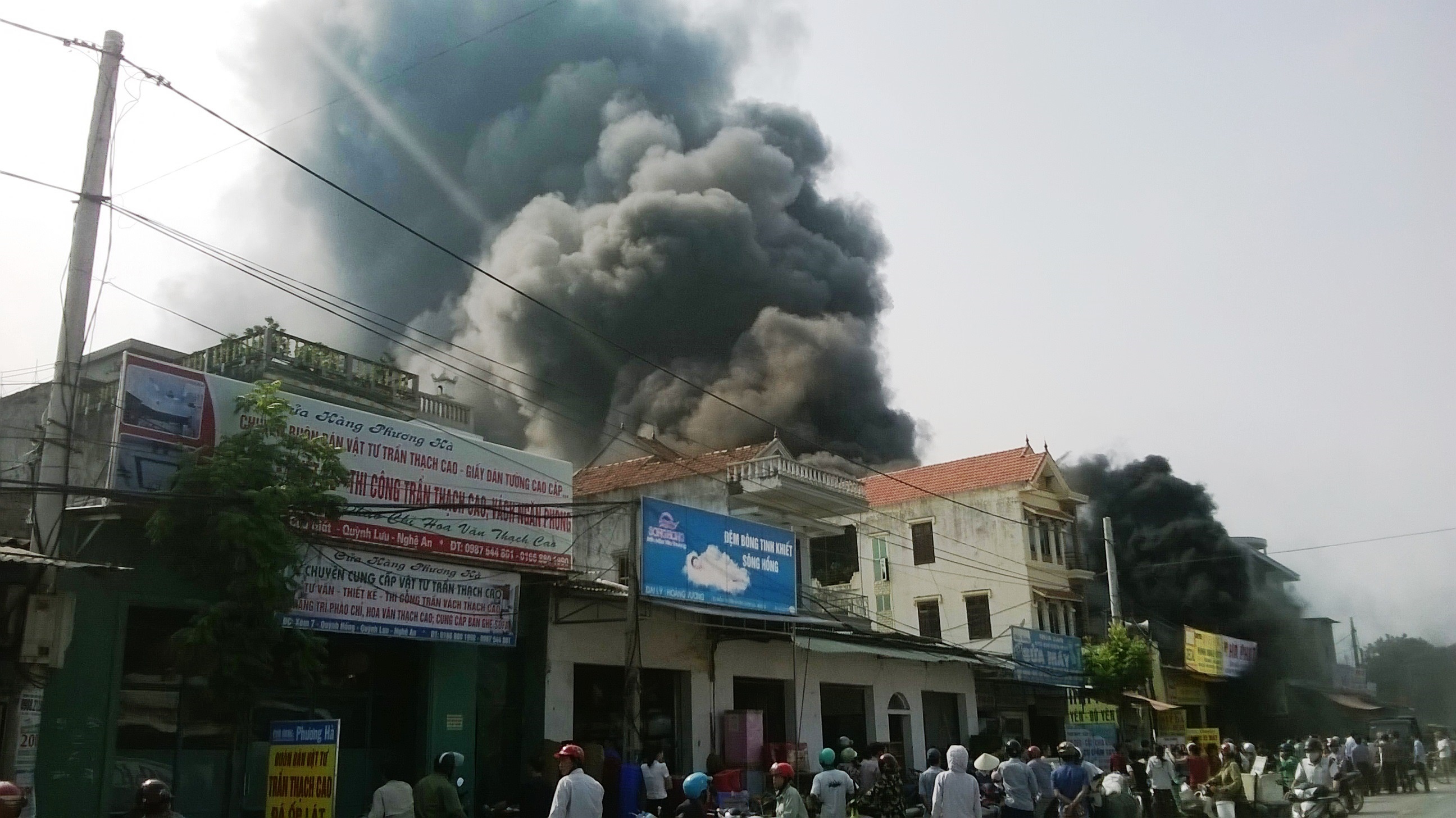 Ghi nhận tại hiện trường, cột khói đen bốc cao hàng chục mét bao trùm lấy cửa hàng và lan rộng sang các nhà bên cạnh.