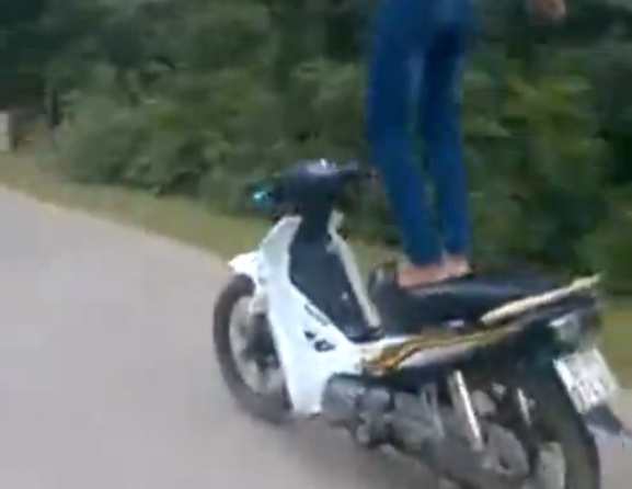 Thanh nien dung tren yen xe may dang chay hinh anh