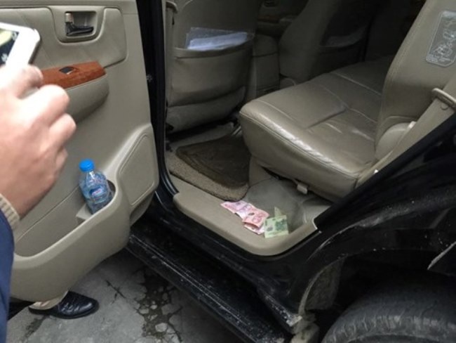 Nhiều tờ tiền mệnh giá từ 50.000 - 100.000 rơi vương vãi trong xe. Ảnh: Khánh Phạm.