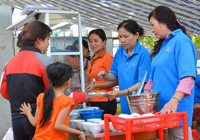 Can bo phuong phuc vu bua trua cho nguoi ngheo hinh anh