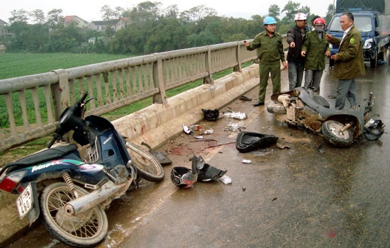 Xe tai tong 3 nguoi tren xe may vang qua lan can cau Ro hinh anh