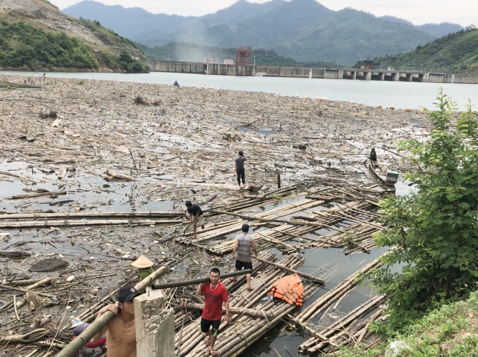 Cong nhan don rac trong long ho thuy dien Ban Ve hinh anh