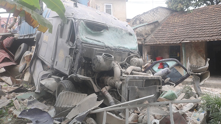 Xe container dam sap nha dan, tai xe mac ket trong cabin hinh anh