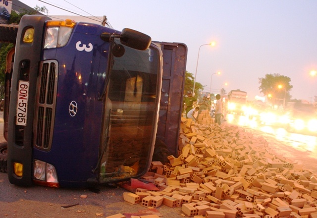 Xe tai lat nghieng, hang ngan vien gach tran xuong duong hinh anh