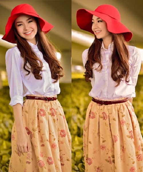 Minh Hằng làm điệu với chân váy xòe nữ tính họa tiết hoa nhí bắt mắt. Cô còn khéo léo mix thêm mũ fedora màu đỏ tươi càng làm nổi bật hơn cho set đồ của mình.