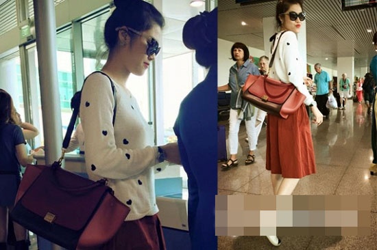 Siêu mẫu Thu Hằng xinh tươi ở sân bay với áo len dệt kim mỏng màu trắng, họa tiết trái tim đen và chân váy dáng xòe, túi đeo vai, kính mắt thời trang.