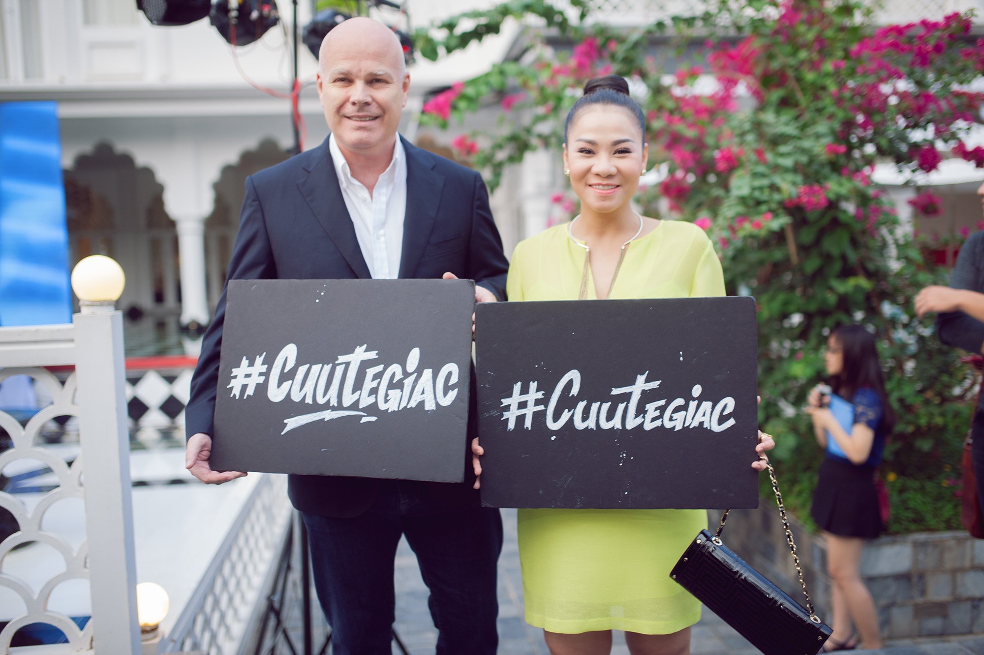 Thu Minh và ông xã cầm bảng kêu gọi mọi người đồng tâm cứu loài động vật quý hiếm.