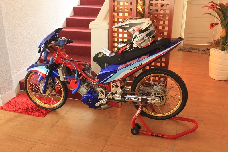 Một chiếc Yamaha drag với các linh kiện được nhập khẩu từ Thái Lan được đặt ngay góc cầu thang. Đây là chiếc xe mơ ước với những tín đồ tốc độ. Vì được tối giản linh kiện, tăng công suất động cơ nên những chiếc dragbike có thể hoàn thành quãng đường 400m chỉ trong vài giây.