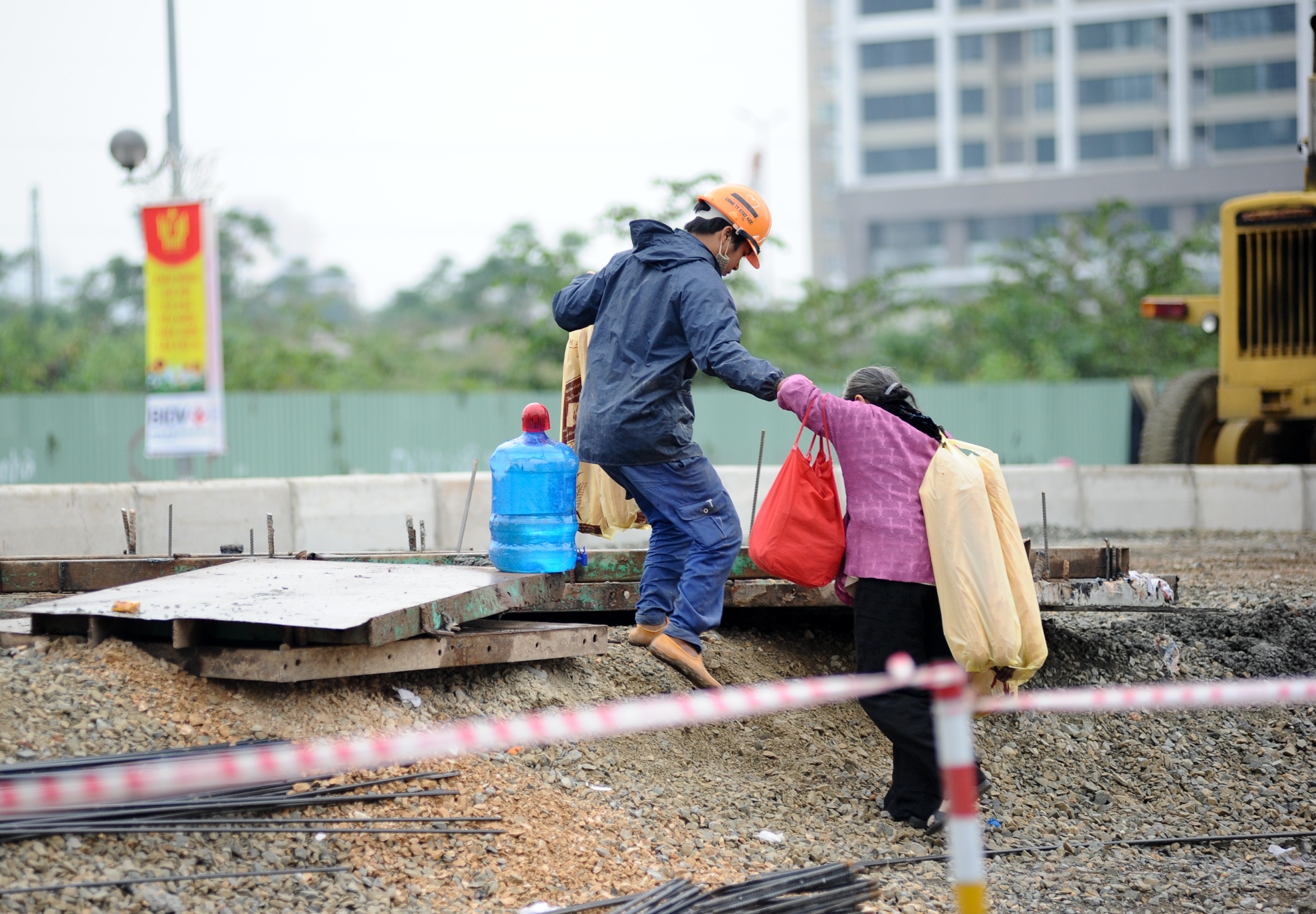 Còn người đi bộ thì lo nơm nớp mỗi khi qua đường. Một bà cụ bán bánh mì đã phải nhờ một anh công nhân để trèo qua đống đất đá do lối đi bộ sang đường đã bị công trường chặn mất.