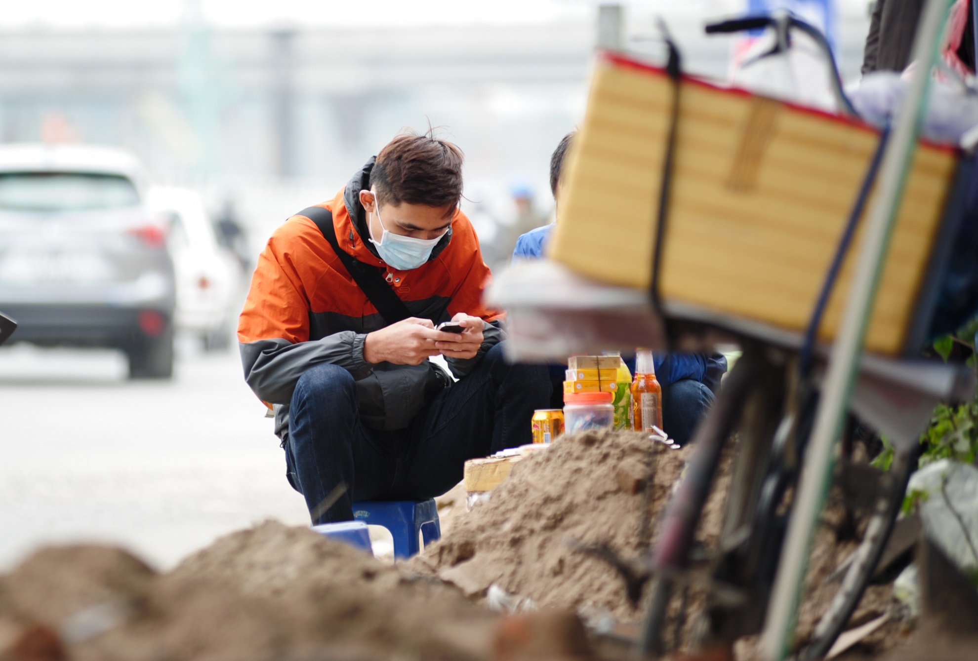 Còn người uống trà đá thì ngồi trên vỉa hè ngổn ngang vật liệu và phải đeo khẩu trang.