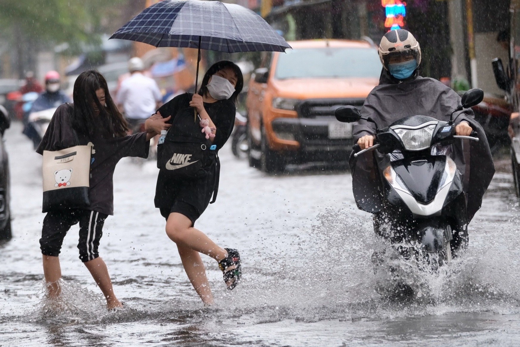 Nu sinh nhay tranh nuoc ban trong con mua lon hinh anh