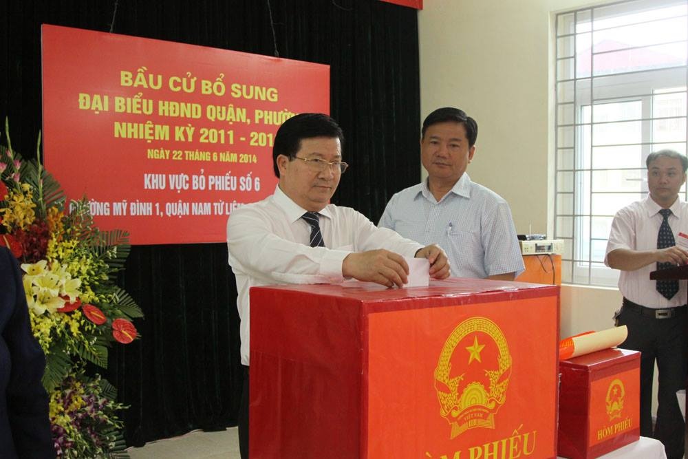 Bộ trưởng Trịnh Đình Dũng và Đinh La Thăng thực hiện nghĩa vụ công dân. Ảnh: H.H.