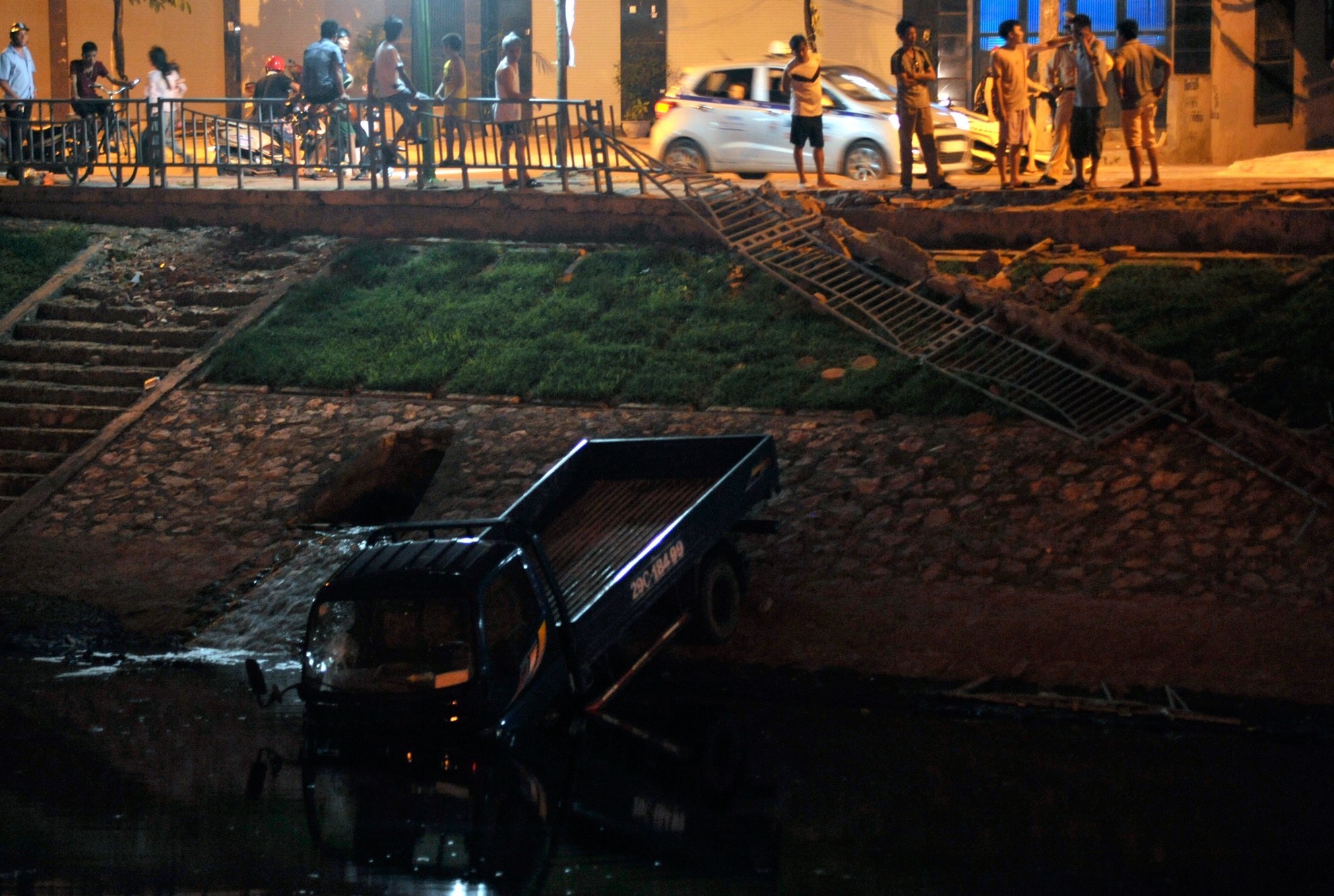 Chiếc xe lao qua dải phân cash, đâm đầu xuống sông. Ảnh: Hoàng Anh.