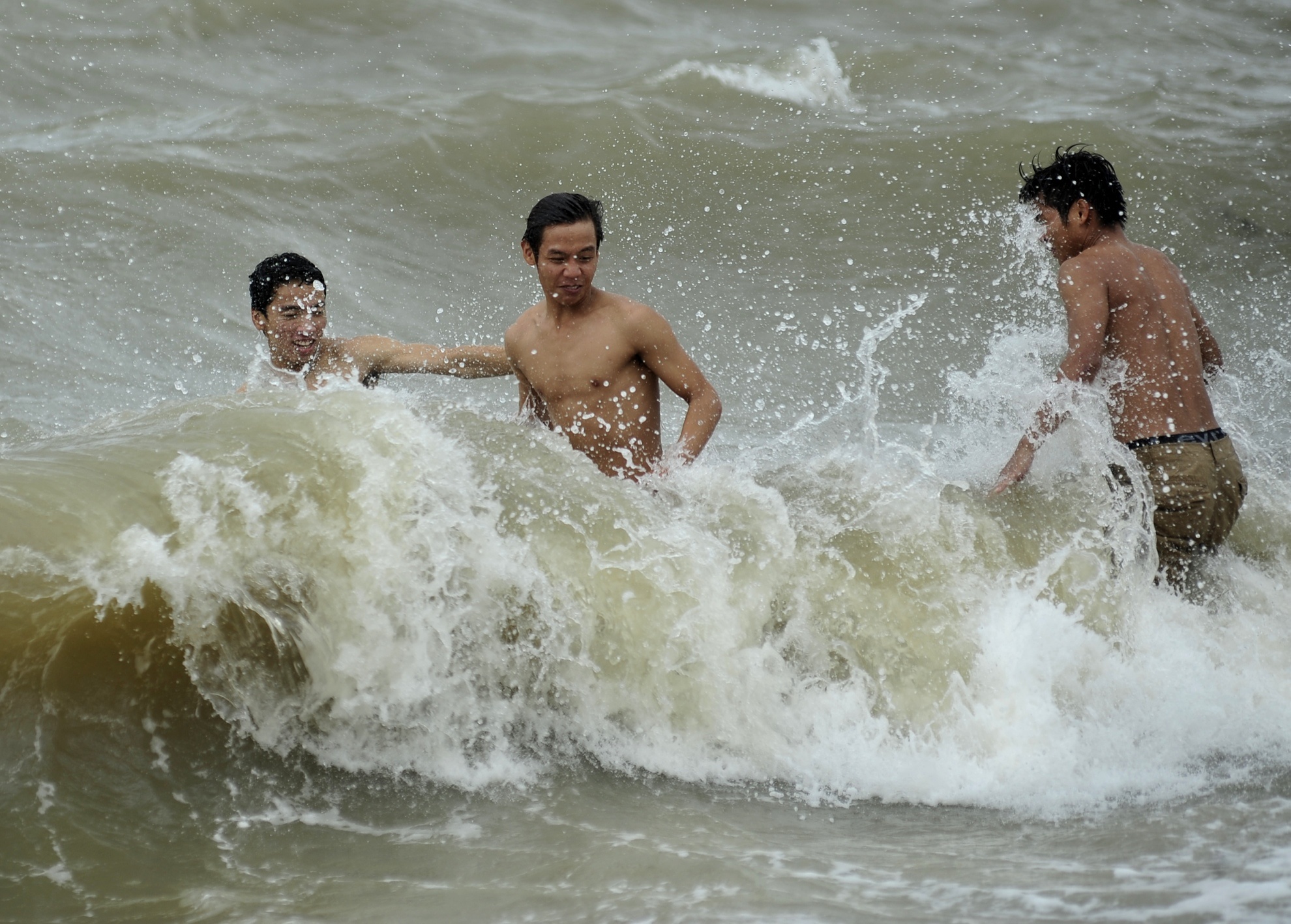 Tuy bão đã tan, trời hửng nắng nhưng gió và sóng khá to nhưng nhiều thanh niên vẫn vô tư ra khu vực bến phà Bãi Cháy cũ tắm biển.