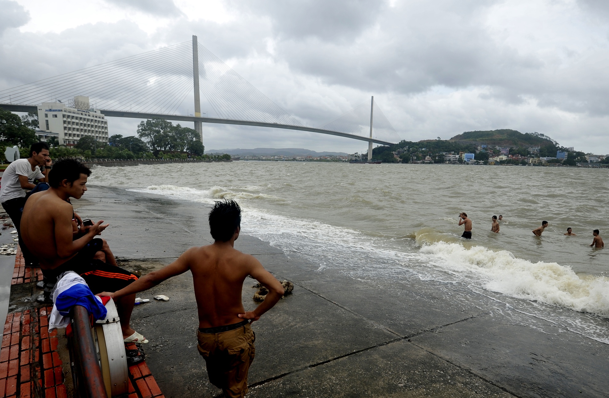 Tuy bão đã tan, trời hửng nắng nhưng gió và sóng khá to nhưng nhiều thanh niên vẫn vô tư ra khu vực bến phà Bãi Cháy cũ tắm biển.