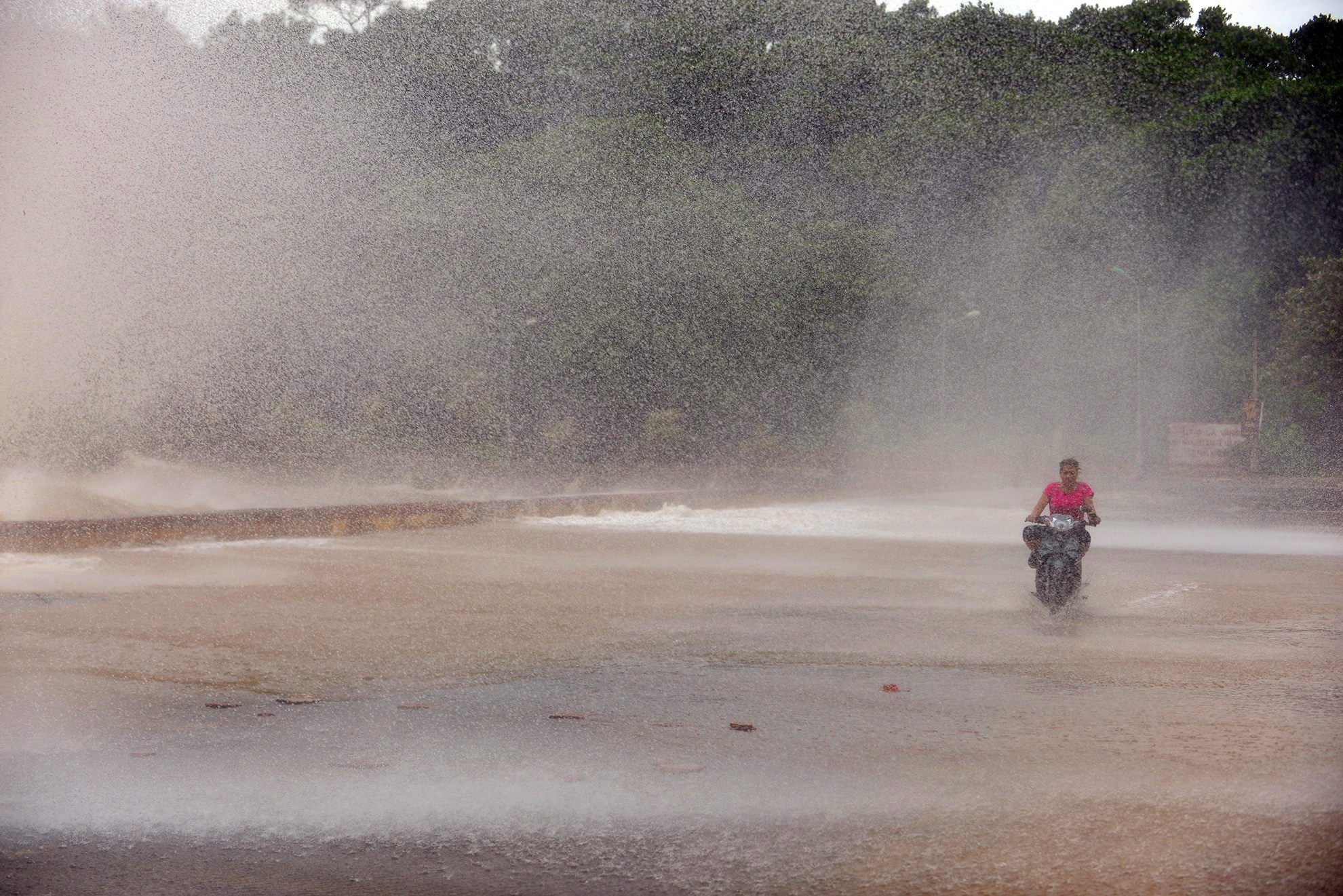 Dù đã tìm cách đi chuyển vào sâu phía trong, người phụ nữ vẫn bị cột nước cao đổ ập vào.