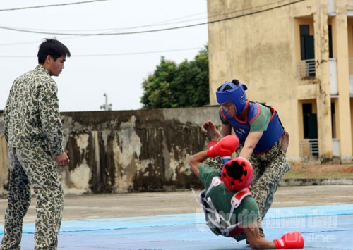 Một chiến sĩ đặc công thể hiện khả năng phi thường, khi cổ họng ghì cong 3 cây đao nhọn, vai kê gạch để đồng đội công phá.
