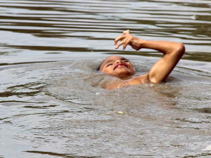 Be trai khuyet tat thoai mai boi tren song hinh anh