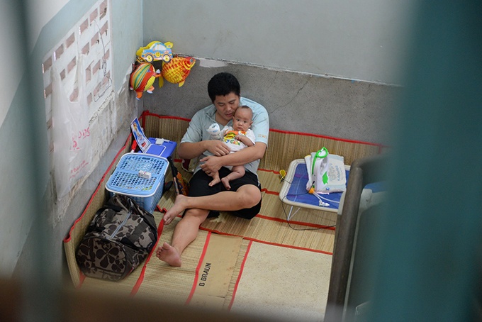 Hai bố con phải ra khoảng trống khu vực cầu thang bệnh viện để nằm điều trị bệnh vì các giường bệnh đều quá tải.