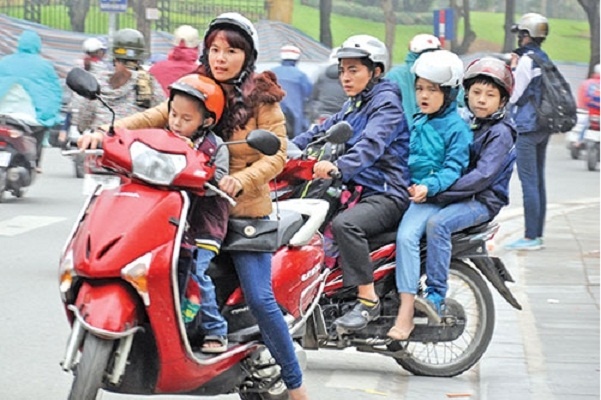 Tiem an nhieu nguy co khi cho tre ngoi truoc xe may mua lanh hinh anh