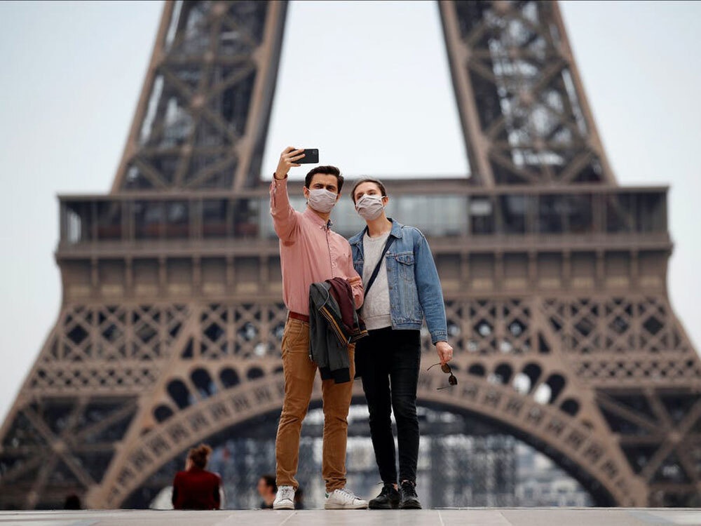 Du khach deo khau trang chup anh tai cac diem den noi tieng the gioi hinh anh