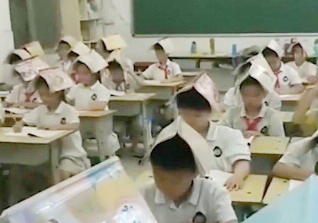 Giao vien Trung Quoc bat hoc sinh doi sach de sua tu the ngoi hinh anh