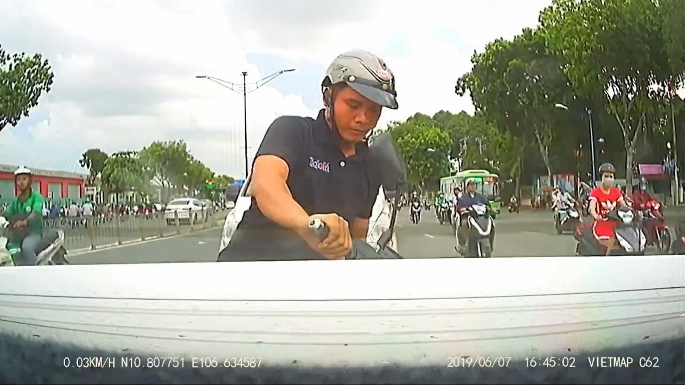 Thanh nien di xe may dam thang duoi oto vi mai bam dien thoai hinh anh