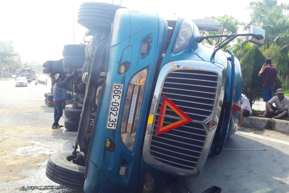 Xe dau keo container lat tren quoc lo 1, hang tram lit dau do ra duong hinh anh