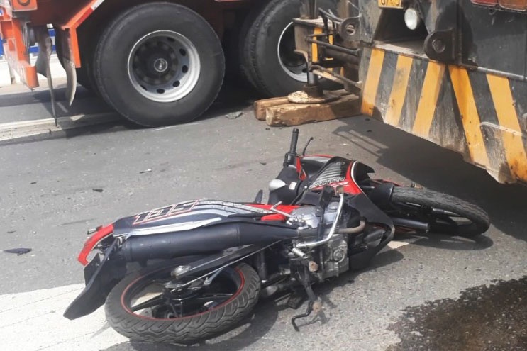 Nguoi dan ong bi xe container keo le tren quoc lo hinh anh