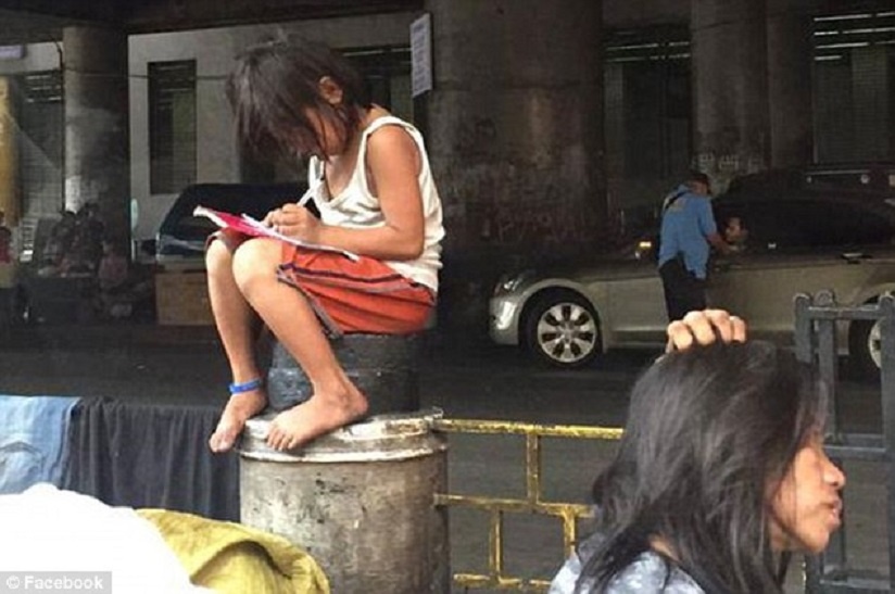 Be gai ngoi hoc tren rao chan khien nhieu nguoi dau long hinh anh