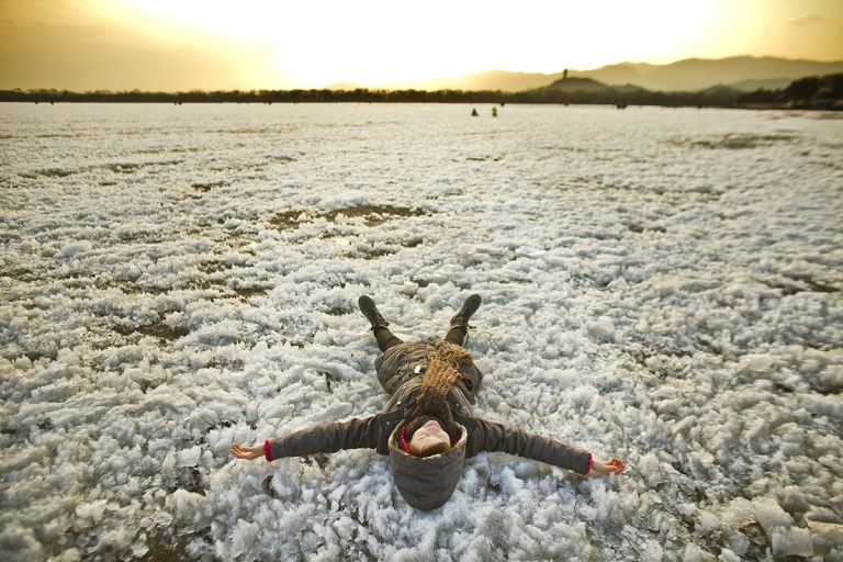 4. Cô bé Feng Xiwen nằm dài trên mặt hồ đóng băng tại Cung điện Mùa hè ở thủ đô Bắc Kinh, Trung Quốc. (Tác giả: Shiho Fukada ).