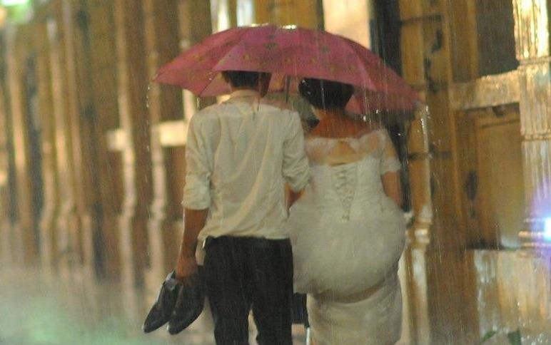 Co dau - chu re nam tay nhau di trong mua bao tai Ha Noi hinh anh