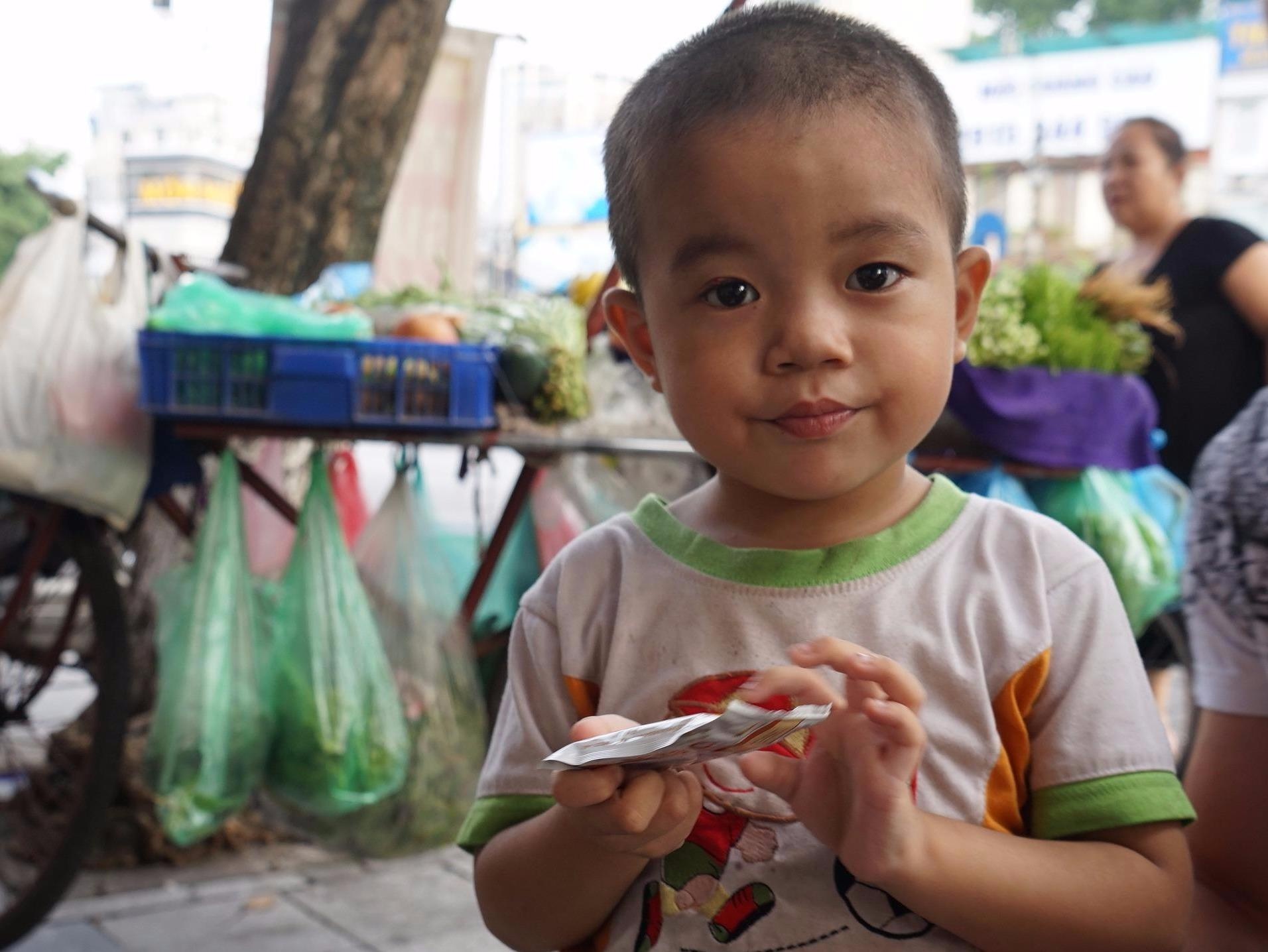 Em be 4 tuoi va vat cho bo tren via he Ha Noi hinh anh