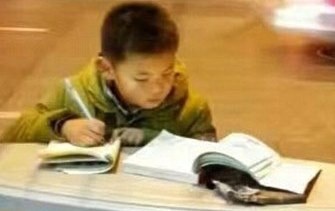 Cau be hoc bai tren nap thung rac ngoai duong pho hinh anh