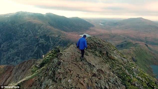 Chang trai chay tren dinh nui hinh anh