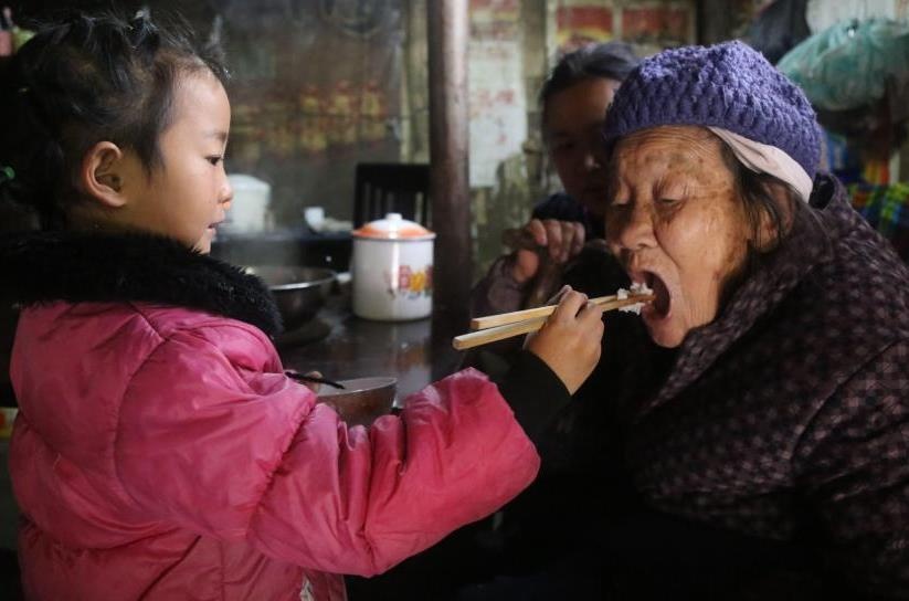 Co be 5 tuoi mot minh ganh vac viec gia dinh hinh anh