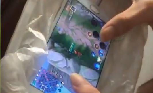 Thanh nien dat dien thoai len khay da de tan nhiet khi choi game hinh anh