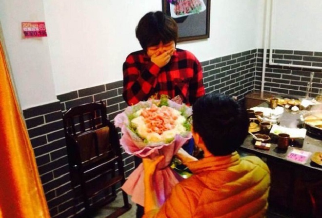 Chàng trai quỳ xuống cầu hôn bạn gái giữa quán ăn. Ảnh: Shanghaiist.