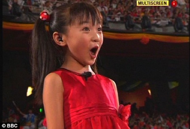 Năm 2007, Lâm Diệu Khả đăng ký dự tuyển và được chọn là 1 trong 56 gương mặt nhí tham gia lễ thượng cờ trên sân vận động Tổ chim (Trung Quốc). Bất ngờ hơn, em nhận lời mời thể hiện bài Ca xướng Tổ quốc trước đại lễ vỏn vẹn 15 phút. Đích thân tổng đạo diễn chương trình, Trương Nghệ Mưu, chỉ định bé. Ảnh: Daily Mail.